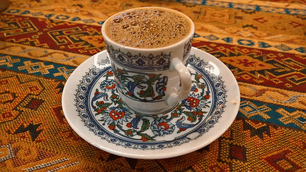 A traditional coffee cup filled with turkish coffee and topped with a lot of foam